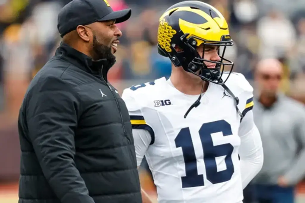 Sherrone Moore of the Wolverines with quarterback Davis Warren.